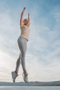 Beautiful woman fitness instructor jumps on the sky background Royalty Free Stock Photo