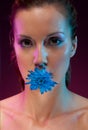 Beautiful woman with flower in mouth