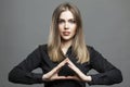 Beautiful woman folded her arms in the shape of a pyramid. Spectacular smiling blonde in a black shirt. Masonic signs and