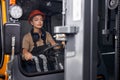 Beautiful woman forklift worker operator driving vehicle at warehouse