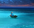 Beautiful woman in the fragile boat in a stormy sea looks at the horizon, hoping for the help Royalty Free Stock Photo