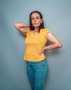 Beautiful woman in full growth, portrait on a blue background, hand on the side