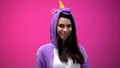 Beautiful woman in funny unicorn costume smiling and posing for camera, fun