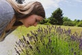 Beautiful woman in the garden smelling flowers. Girl smelling a bouquet of lavender on a hot summer day. aged Royalty Free Stock Photo