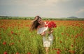 beautiful woman gather red poppy flower bouquet in field. summer or spring nature. seasonal beauty landscape. young girl