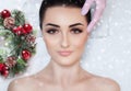 A beautiful woman gets a facial massage in the spa salon. Closeup of woman`s face and new year wreath