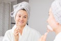 Beautiful woman is getting massage face using jade roller in front of the mirror at home Royalty Free Stock Photo