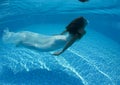 Beautiful woman girl white dress underwater diving swim blue sunny day pool Royalty Free Stock Photo