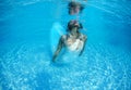 Beautiful woman girl white dress underwater diving swim blue sunny day pool Royalty Free Stock Photo