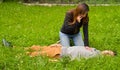 Beautiful woman giving first aid to a handsome young man and using her cellphone to call the ambulance, cardiopulmonary