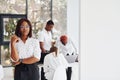 Beautiful woman in glasses in front of her colleagues. Group of african american business people working in office together Royalty Free Stock Photo