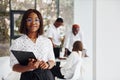 Beautiful woman in glasses in front of her colleagues. Group of african american business people working in office together Royalty Free Stock Photo