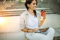 Beautiful woman is going to work with coffee walking near office buildings. Portrait of a successful business woman holding a cup Royalty Free Stock Photo