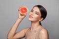 Beautiful woman with grapefruit in her hands. Smiling woman brunette with grapefruit portrait Royalty Free Stock Photo