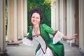 Beautiful woman in green medieval dress doing curtsey