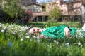 Beautiful woman in green shirt lying down among daisies smiling Royalty Free Stock Photo