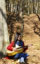 Beautiful woman guitar player girl in the forest Royalty Free Stock Photo