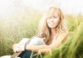 Beautiful woman with guitar sitting on grass. Royalty Free Stock Photo