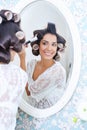 Beautiful woman in hair curlers puts on morning makeup Royalty Free Stock Photo