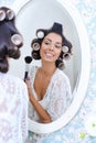 Beautiful woman in hair curlers puts on morning makeup Royalty Free Stock Photo