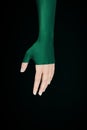 Beautiful woman hand with half green make up tone in tone on green background Royalty Free Stock Photo