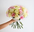 Beautiful woman hand hold bouquet of yellow and pink roses flowers on white Royalty Free Stock Photo