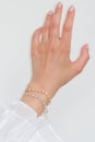 Woman hand and wrist wearing zircon sparkle bracelets set against a white background Royalty Free Stock Photo
