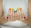 Beautiful woman hands with colorful rainbow nail polish