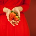 Beautiful woman hands holding some strawberries in her hands