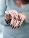 Beautiful woman hands with light white manicure and a bottle of nail polish