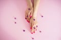 Beautiful woman hands and lilac flowers on a pink background, top view. Beautiful manicure