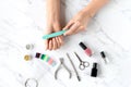 Beautiful woman hands making manicure with nail file on marble table with manicure set. Royalty Free Stock Photo