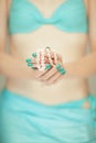 Beautiful woman hands with perfect blue nail polish holding coral necklace, happy bikini beach mood Royalty Free Stock Photo