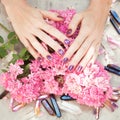 Beautiful woman hands with perfect violet nail polish on white wooden background holding little quartz crystals