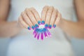 Beautiful woman hands with perfect violet pink and turquoise nail polish