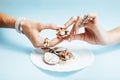 Beautiful woman hands with pink manicure holding plate with pearls and sea shells, luxury jewelry concept