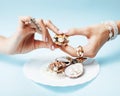 Beautiful woman hands with pink manicure holding plate with pearls and sea shells, luxury jewelry concept Royalty Free Stock Photo