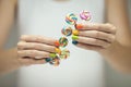 Beautiful woman hands with rainbow nail polish holding colorful swirl lollypops, funny cheerful