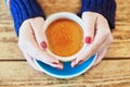 Beautiful woman hands with red manicure and cup of fresh hot coffee on wooden table Royalty Free Stock Photo