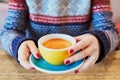 Beautiful woman hands with red manicure and cup of fresh hot coffee on wooden table Royalty Free Stock Photo