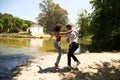 beautiful woman and handsome man latinos dancing bachata are dancing by the river in the forest. The couple do different postures Royalty Free Stock Photo