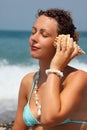 Beautiful woman has leant seashell bowl to an ear Royalty Free Stock Photo