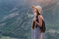 Beautiful woman in hat on the background of nature and see into the distance. Portrait back view