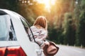 Beautiful woman in hat enjoying view of the road from the car window