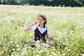 beautiful woman in a hat in a field of chamomile flowers Royalty Free Stock Photo