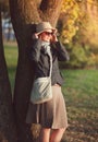 Beautiful woman in hat and scarf enjoy sunlight in the city Royalty Free Stock Photo