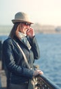 Beautiful woman in hat and scarf with mobile phone in the city Royalty Free Stock Photo