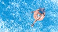 Beautiful woman in hat in swimming pool aerial top view from above, young girl in bikini relaxes and swims on inflatable ring Royalty Free Stock Photo