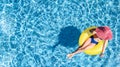 Beautiful woman in hat in swimming pool aerial top view from above, young girl in bikini relaxes swims on inflatable ring donut Royalty Free Stock Photo