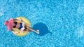 Beautiful woman in hat in swimming pool aerial view from above, young girl in bikini relaxes and swims on inflatable ring donut Royalty Free Stock Photo